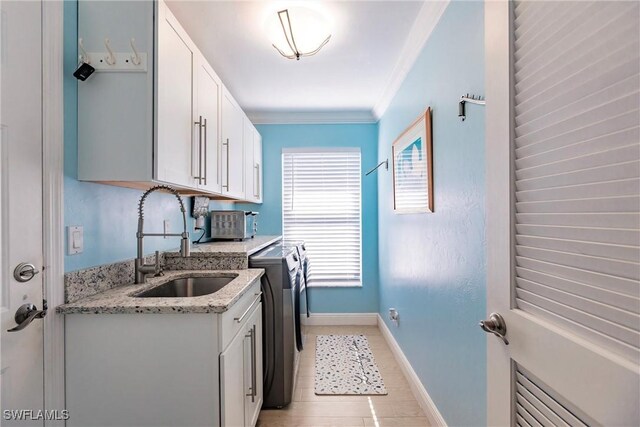 kitchen with crown molding, sink, washer and dryer, and white cabinets