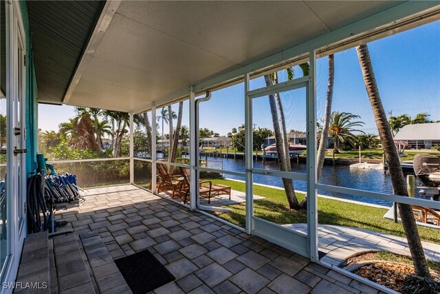 unfurnished sunroom featuring a water view