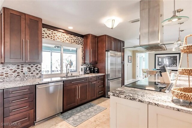 kitchen featuring sink, island exhaust hood, stainless steel appliances, light stone countertops, and backsplash