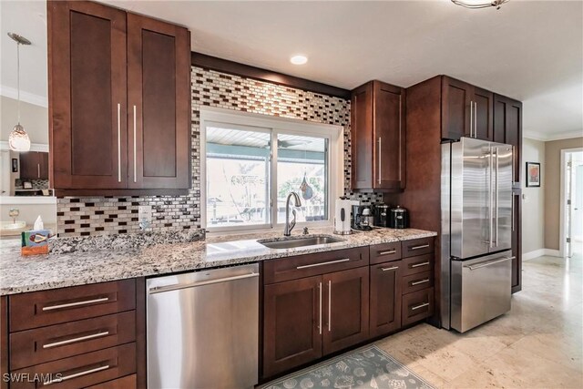 kitchen featuring light stone counters, stainless steel appliances, a sink, tasteful backsplash, and crown molding