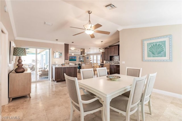 dining space featuring crown molding, lofted ceiling, visible vents, a ceiling fan, and baseboards