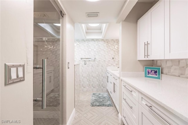 full bathroom featuring a stall shower, vanity, and visible vents