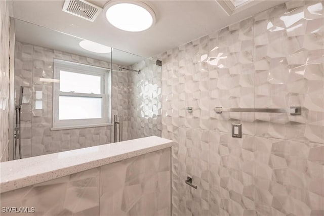 bathroom featuring tile walls and tiled shower