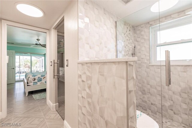 bathroom with a shower with door, plenty of natural light, parquet floors, and ceiling fan