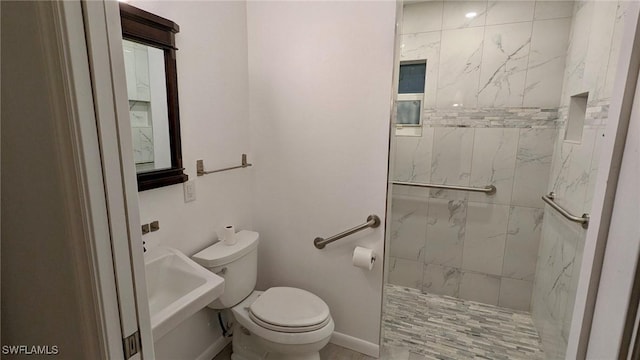 bathroom featuring toilet, sink, and a tile shower