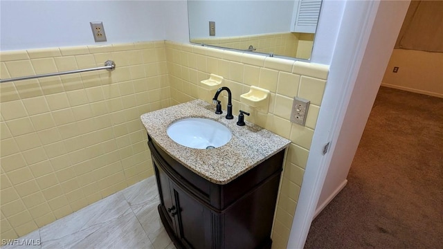 bathroom featuring vanity and tile walls