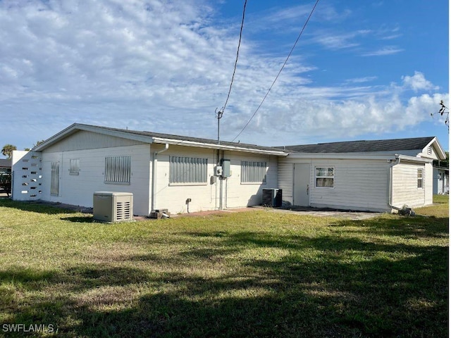 back of house featuring a yard and central AC unit