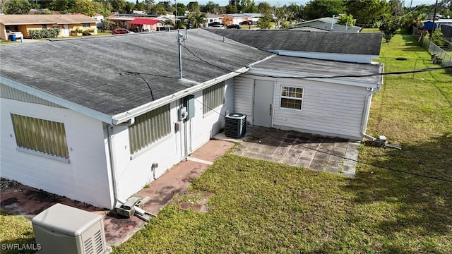 back of house with a lawn and central air condition unit