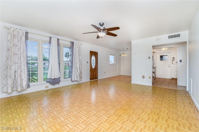 804 Bougainvillea Rd E, Lehigh Acres, FL 33936 - unfurnished living room with a ceiling fan, a chandelier, and baseboards