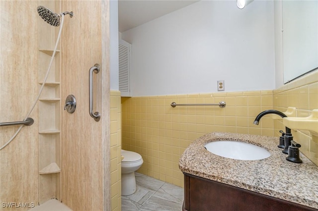 804 Bougainvillea Rd E, Lehigh Acres, FL 33936 - full bath with vanity, toilet, a shower, tile walls, and a wainscoted wall