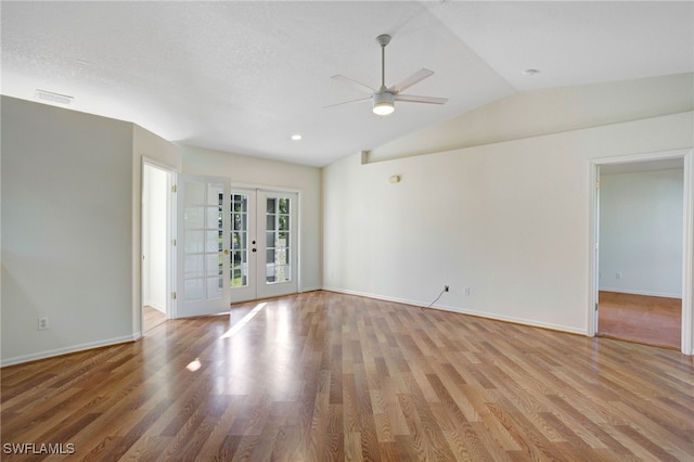 unfurnished room featuring french doors, light hardwood / wood-style floors, ceiling fan, and lofted ceiling