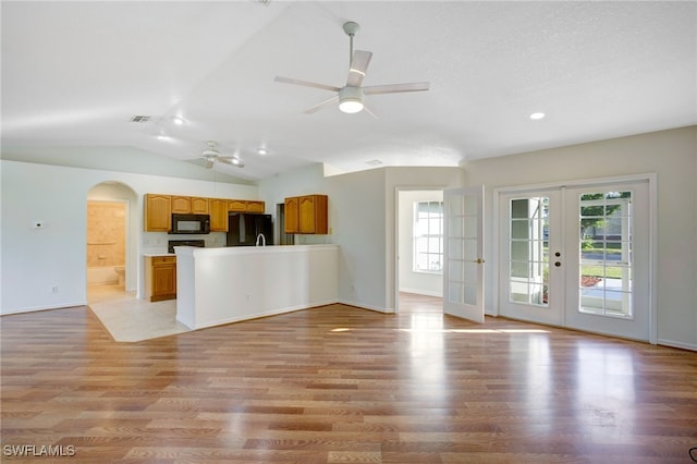 kitchen featuring french doors, vaulted ceiling, ceiling fan, black appliances, and light hardwood / wood-style flooring