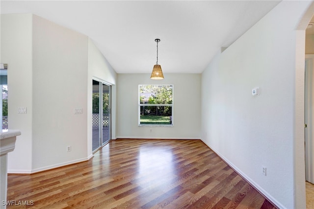 unfurnished dining area featuring hardwood / wood-style floors and lofted ceiling