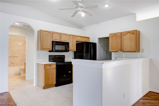 kitchen with lofted ceiling, black appliances, sink, ceiling fan, and light tile patterned floors