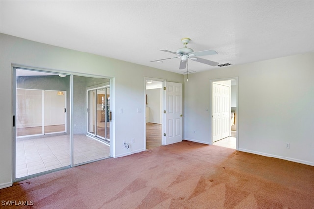 unfurnished bedroom featuring light carpet, a closet, and ceiling fan