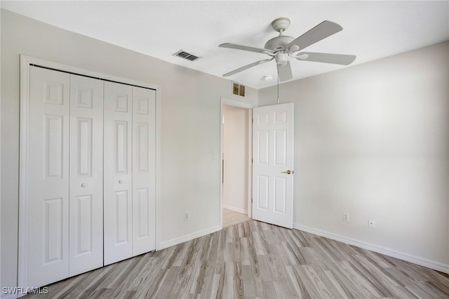 unfurnished bedroom featuring ceiling fan, a closet, and light hardwood / wood-style flooring