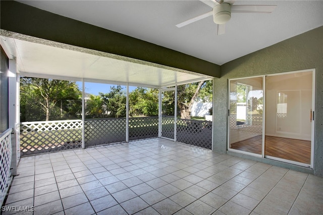 unfurnished sunroom featuring ceiling fan and vaulted ceiling