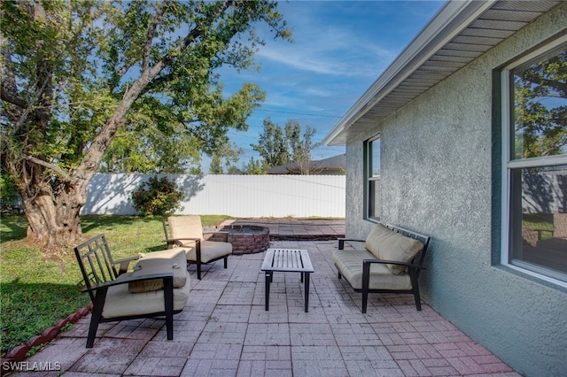 view of patio with an outdoor living space with a fire pit