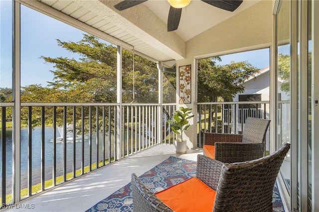 sunroom / solarium featuring a water view, plenty of natural light, and lofted ceiling