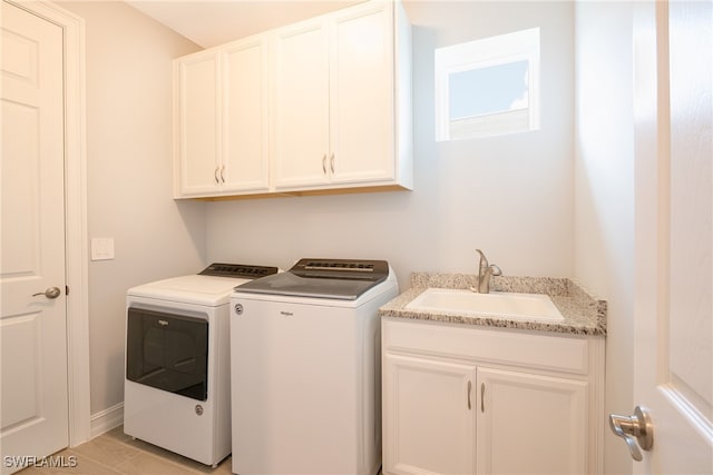 laundry room with washer and dryer, sink, and cabinets