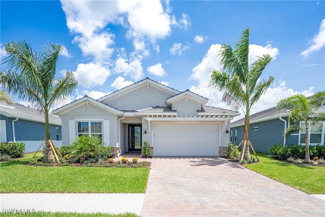 view of front of property featuring a garage and a front lawn