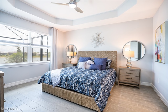 bedroom featuring a raised ceiling and ceiling fan