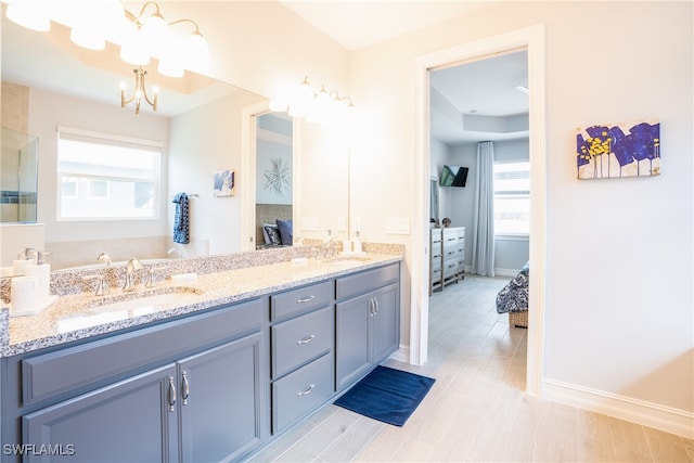 bathroom featuring hardwood / wood-style flooring, vanity, plenty of natural light, and a chandelier