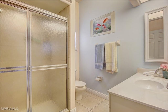 bathroom featuring vanity, a shower with door, tile patterned floors, and toilet