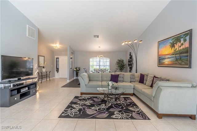 living room featuring light tile patterned floors, vaulted ceiling, and a notable chandelier