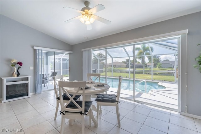 dining room featuring ceiling fan, light tile patterned floors, and lofted ceiling