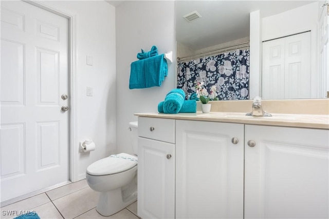 bathroom with tile patterned flooring, vanity, and toilet