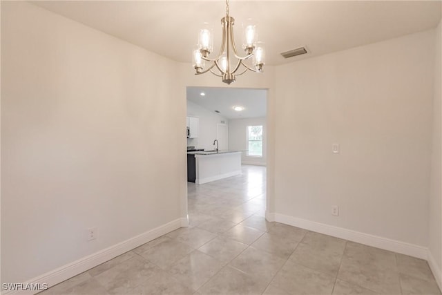 interior space with light tile patterned floors, an inviting chandelier, and sink