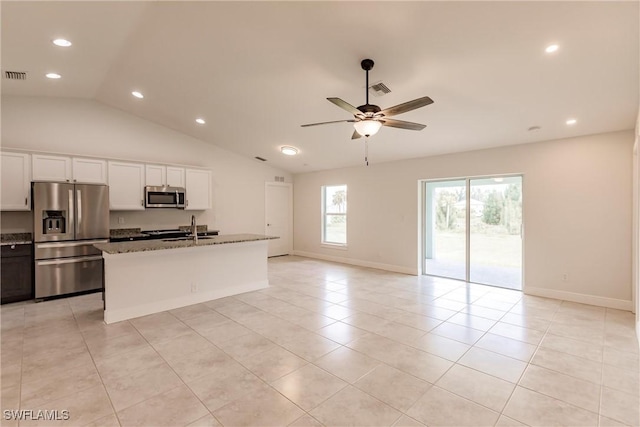 kitchen with a kitchen island with sink, ceiling fan, light stone countertops, white cabinetry, and stainless steel appliances