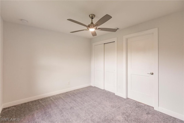 unfurnished bedroom featuring ceiling fan, a closet, and carpet