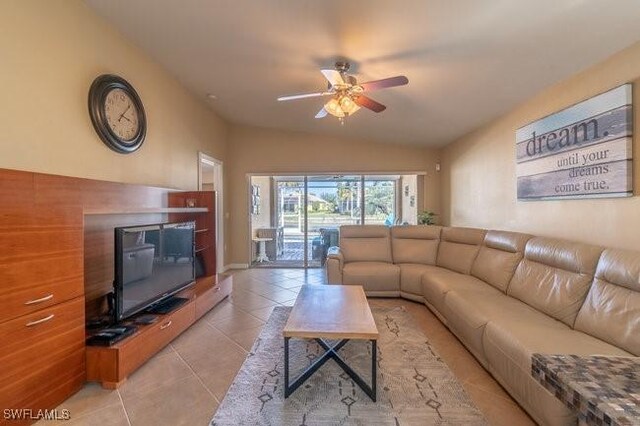 living room featuring vaulted ceiling, ceiling fan, and light tile patterned flooring