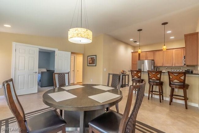 dining area featuring light tile patterned flooring and lofted ceiling