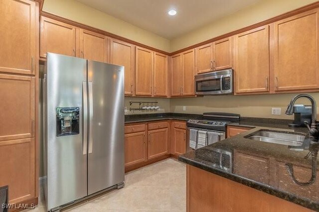 kitchen with dark stone countertops, sink, and appliances with stainless steel finishes