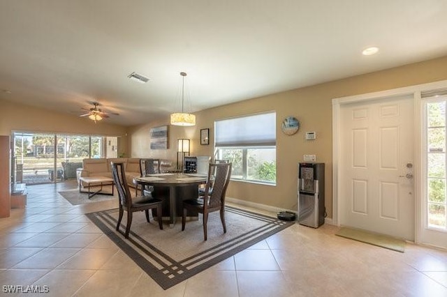 tiled dining space featuring ceiling fan, plenty of natural light, and vaulted ceiling