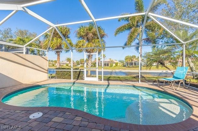 view of swimming pool featuring a lanai, a water view, and a patio