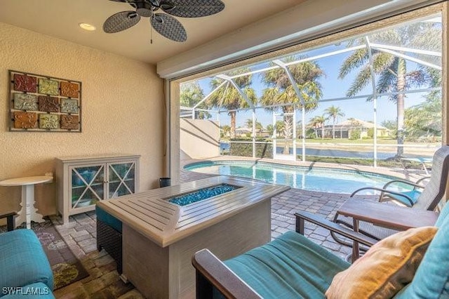 view of patio featuring a fire pit, ceiling fan, and a lanai