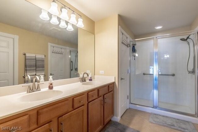 bathroom with tile patterned floors, vanity, and a shower with door