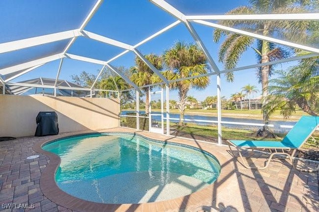 outdoor pool featuring glass enclosure and a patio area