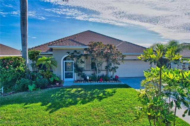 mediterranean / spanish-style home with a garage and a front lawn