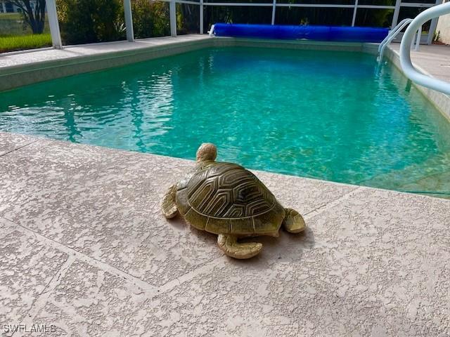 view of swimming pool featuring a patio and glass enclosure