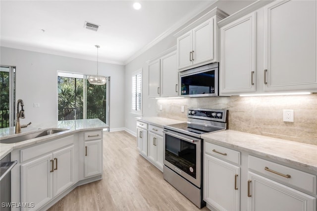 kitchen featuring backsplash, white cabinets, sink, appliances with stainless steel finishes, and light hardwood / wood-style floors