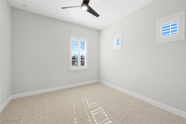 carpeted spare room with ceiling fan