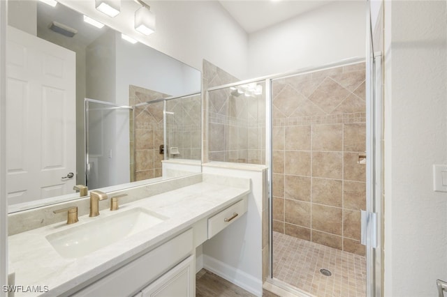 bathroom with vanity and a shower with door