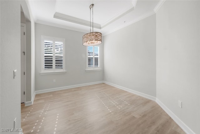 spare room with crown molding and a tray ceiling