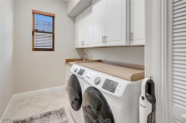 clothes washing area featuring cabinets, separate washer and dryer, sink, and light tile patterned floors