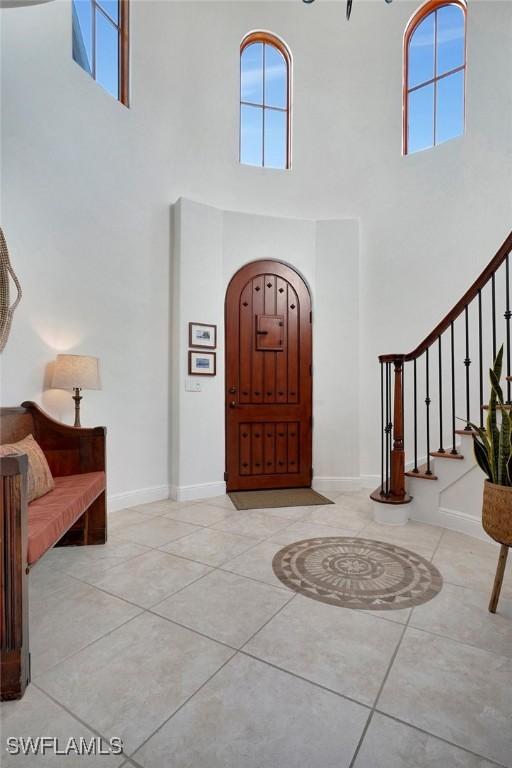 foyer entrance featuring a high ceiling and light tile patterned flooring